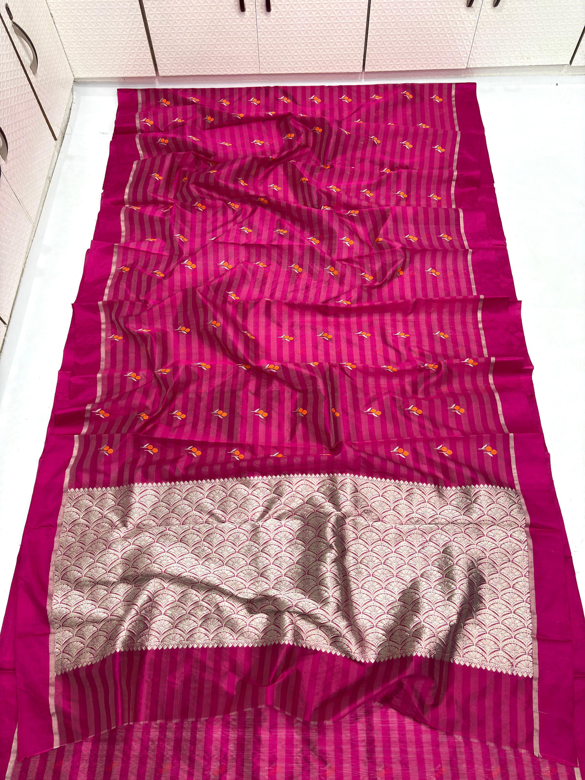 Draped Raspberry Pink Pattu Silk Chanderi showing striped body, colourful woven motifs and detailed metallic pallu.