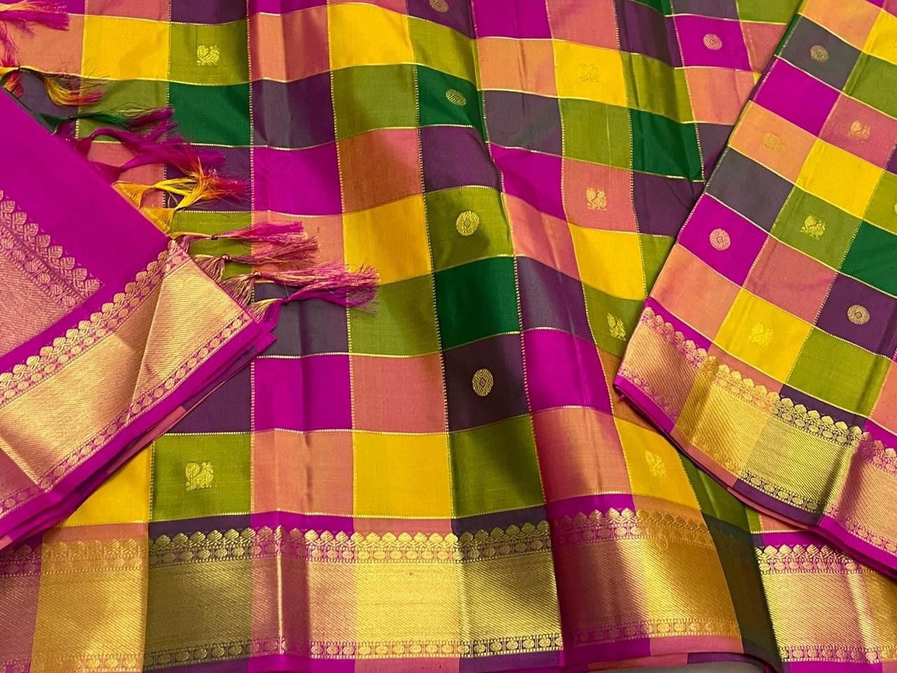 Close-up of multicolor checked Kanchipuram silk saree with zari woven gold border and magenta pallu weave.