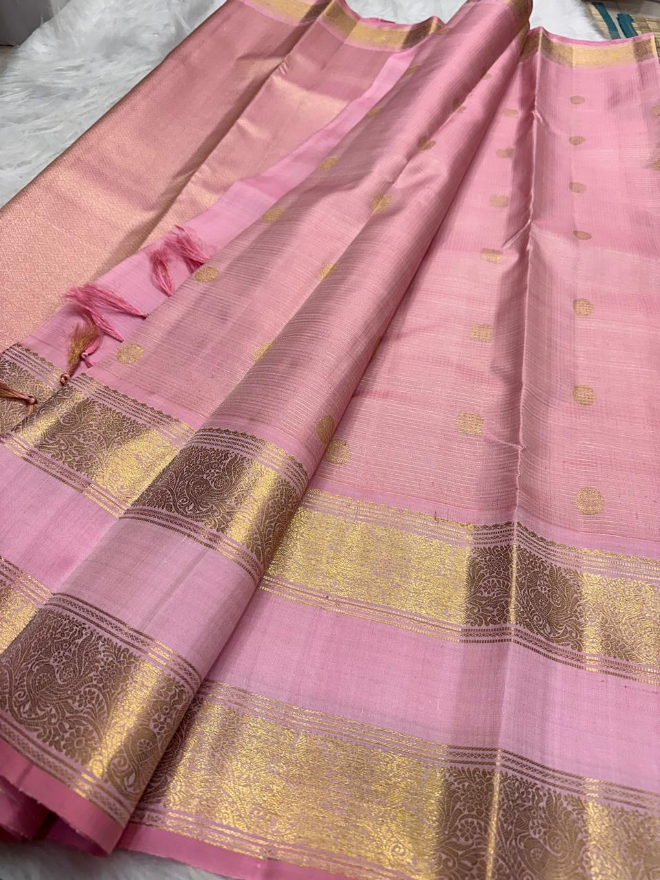 Close-up of gold zari buttas on blush pink Kanjipuram Zari Kattam saree