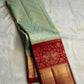 Pista green handwoven pure silk Kanchipuram Butta saree with red zari border