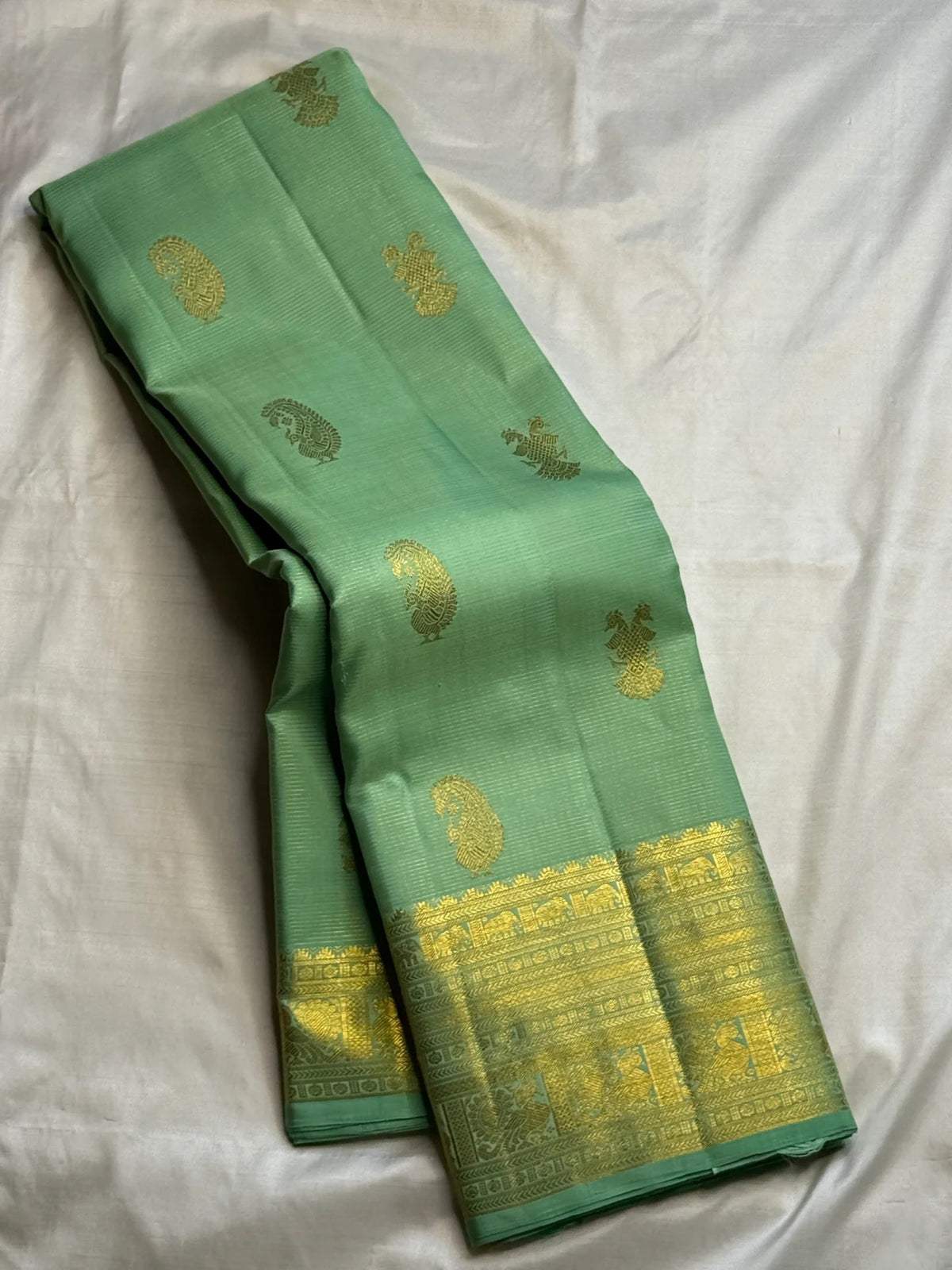 Pistachio-green Pure Silk Kanjipuram Butta saree with alternating Gandaberunda and paisley zari motifs.