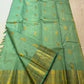 Detail of alternating Gandaberunda and paisley motifs woven across the pale-green silk body.