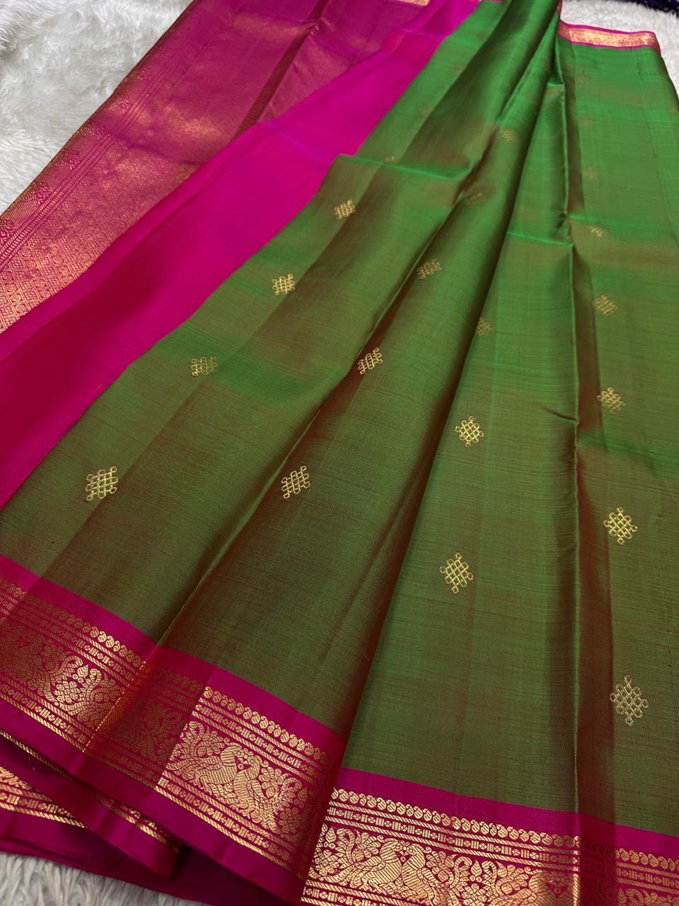 Draped olive green pure Kanchipuram silk saree with gold buttas and magenta zari woven border beside the pallu.