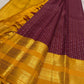 Manjal yellow pallu on the plum purple Kanchipuram zari kattam saree.