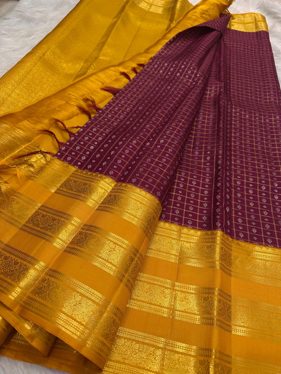 Manjal yellow pallu on the plum purple Kanchipuram zari kattam saree.