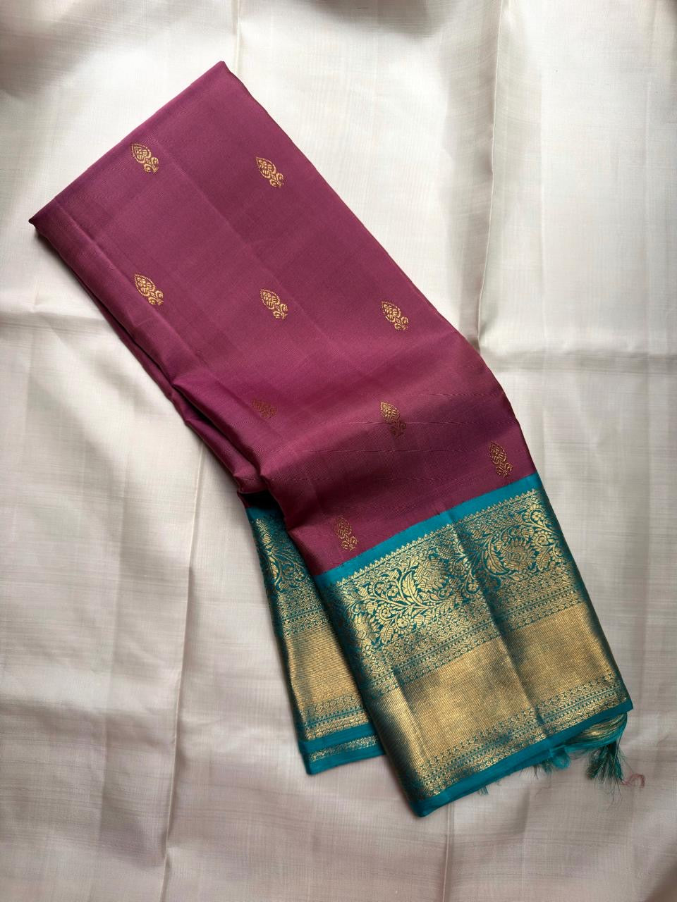 Plum Kanjivaram silk saree with petite Maanga gold buttas and Turquoise Pettu