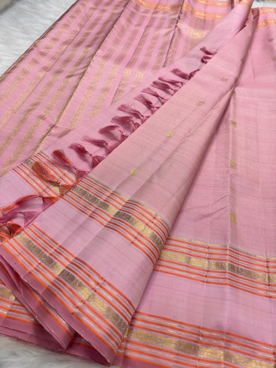Soft pink Kanjipuram saree with delicate zari border