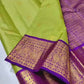 Verdant Gold ✨ – Parrot Green & Violet Pure Kanchipuram Silk Saree
 Gold Zari Buttas in Kattam Weave
Violet Korvai Border with Peacock & Floral Zari Motifs
Grand Violet Brocade Pallu with  Tassels done 
Violet Blouse with Zari Border | Silk Mark