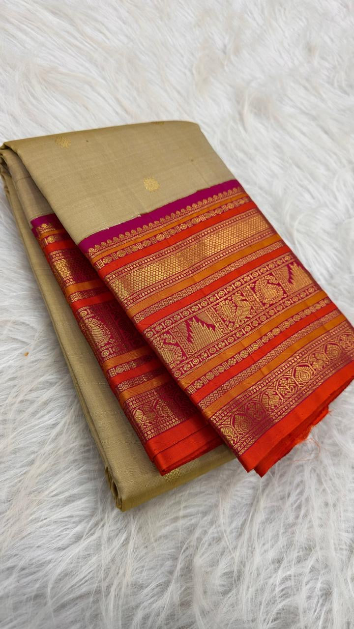 Close view of Mayil gold zari motifs woven into Rani Pink and orange Varisaipet border.