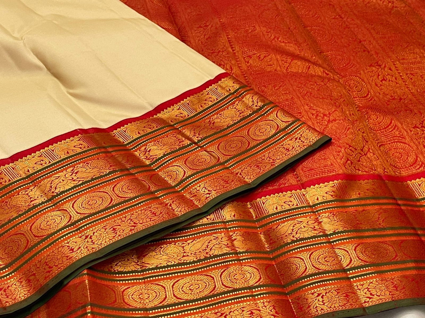 Full spread showing ivory body and red zari woven pallu with intricate patterning on a pure Kanchipuram silk saree.