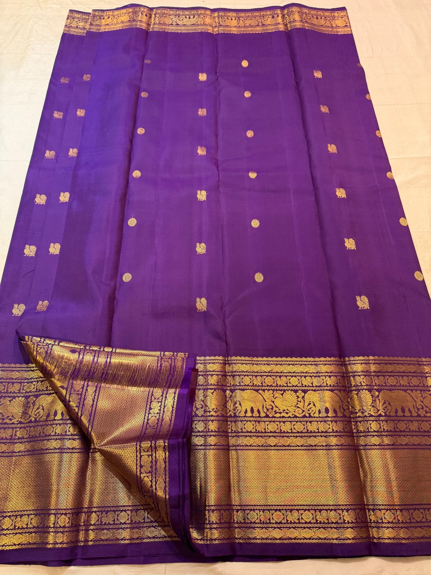Elephant and peacock zari border detail on royal purple Kanjipuram saree