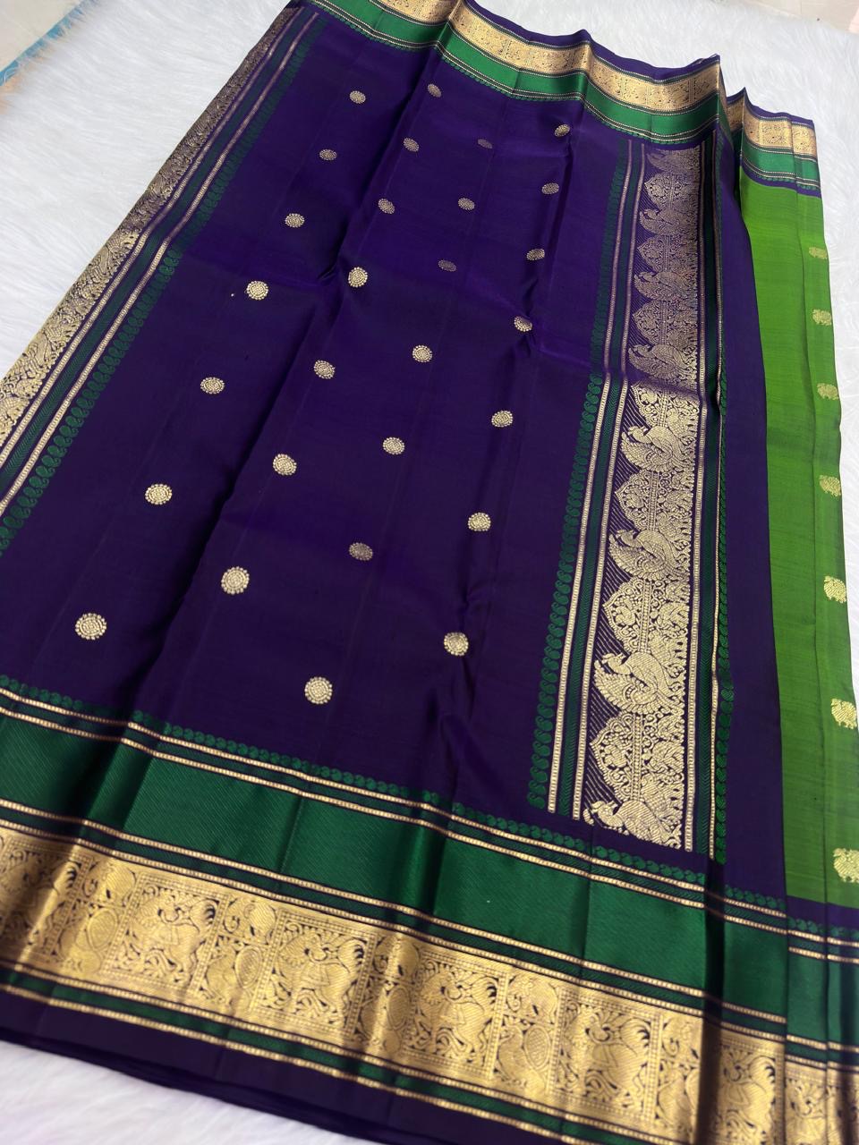Leaf green Kanjivaram silk saree folded, showing Butta motifs and peacock border