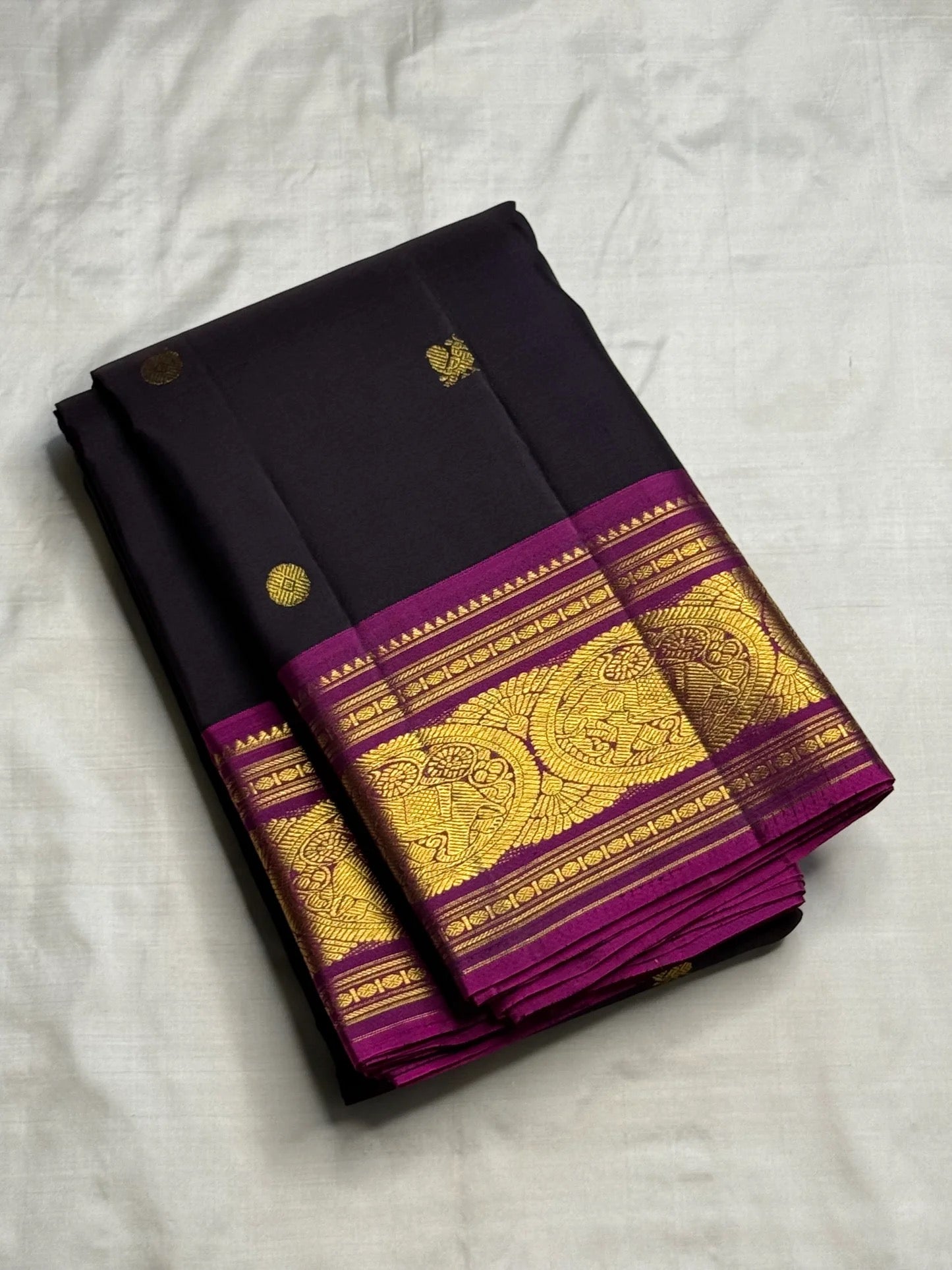 Vivid magenta Korvai border detail with zari medallions on deep aubergine KanchiPattu saree