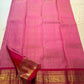 Rose pink Kanjeevaram Korvai silk saree folded, showing raspberry-red border detail