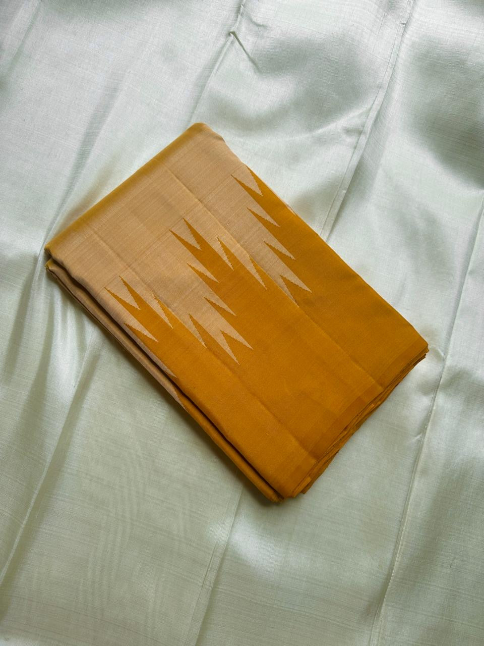 Folded Pure Kanchipuram Silk Saree in mustard and beige with temple motif border, available in the USA