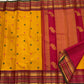 Raspberry pink zari border detail on the golden turmeric pure silk Kanchipuram saree.