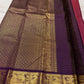 Raspberry red Kanchipuram silk saree folded, showing checked body, aubergine peacock border and pallu