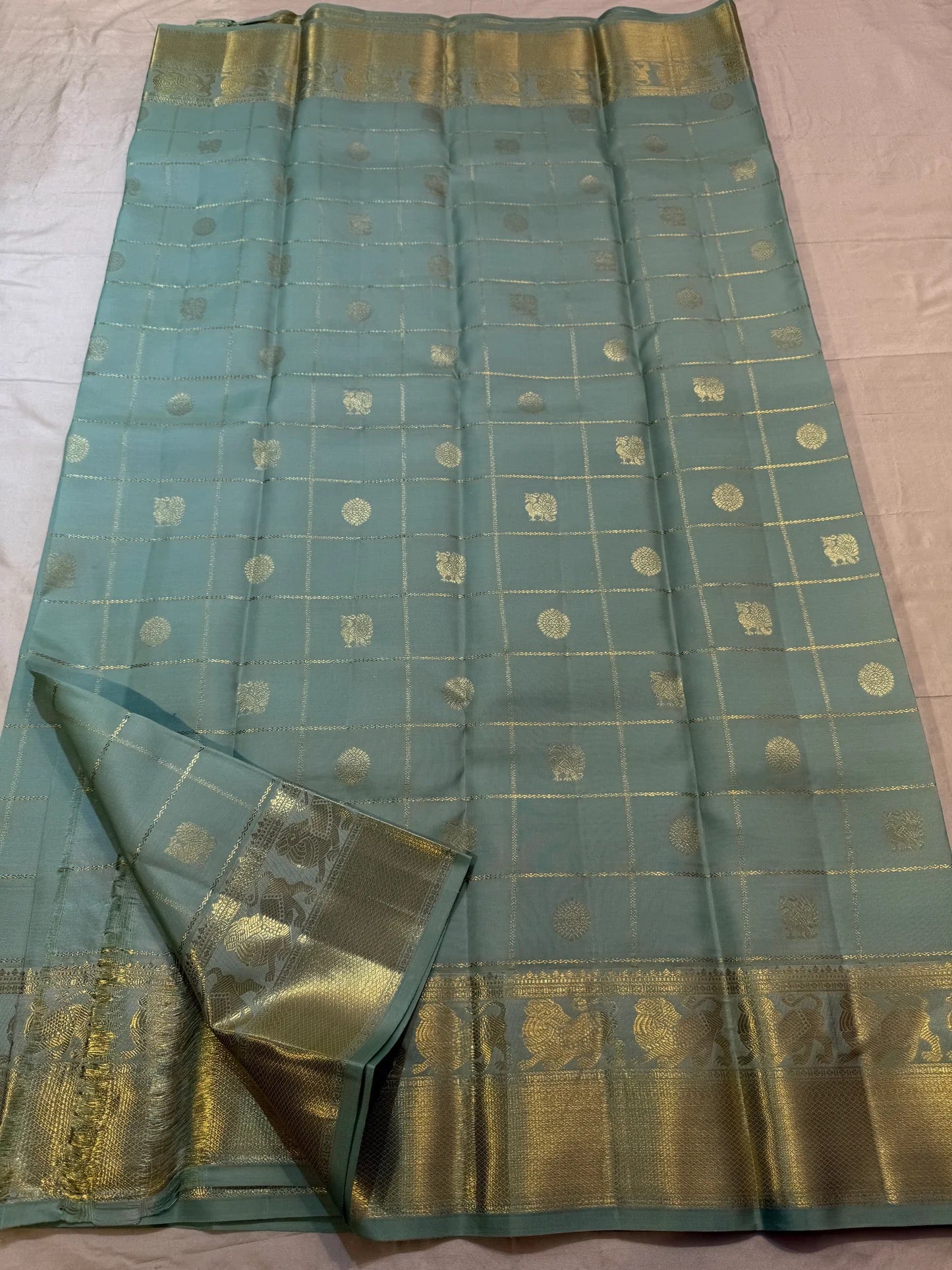 Mayil and Kamalam zari buttas within the Zari Kattam checks, dewdrop sage green Kanjeevaram saree.