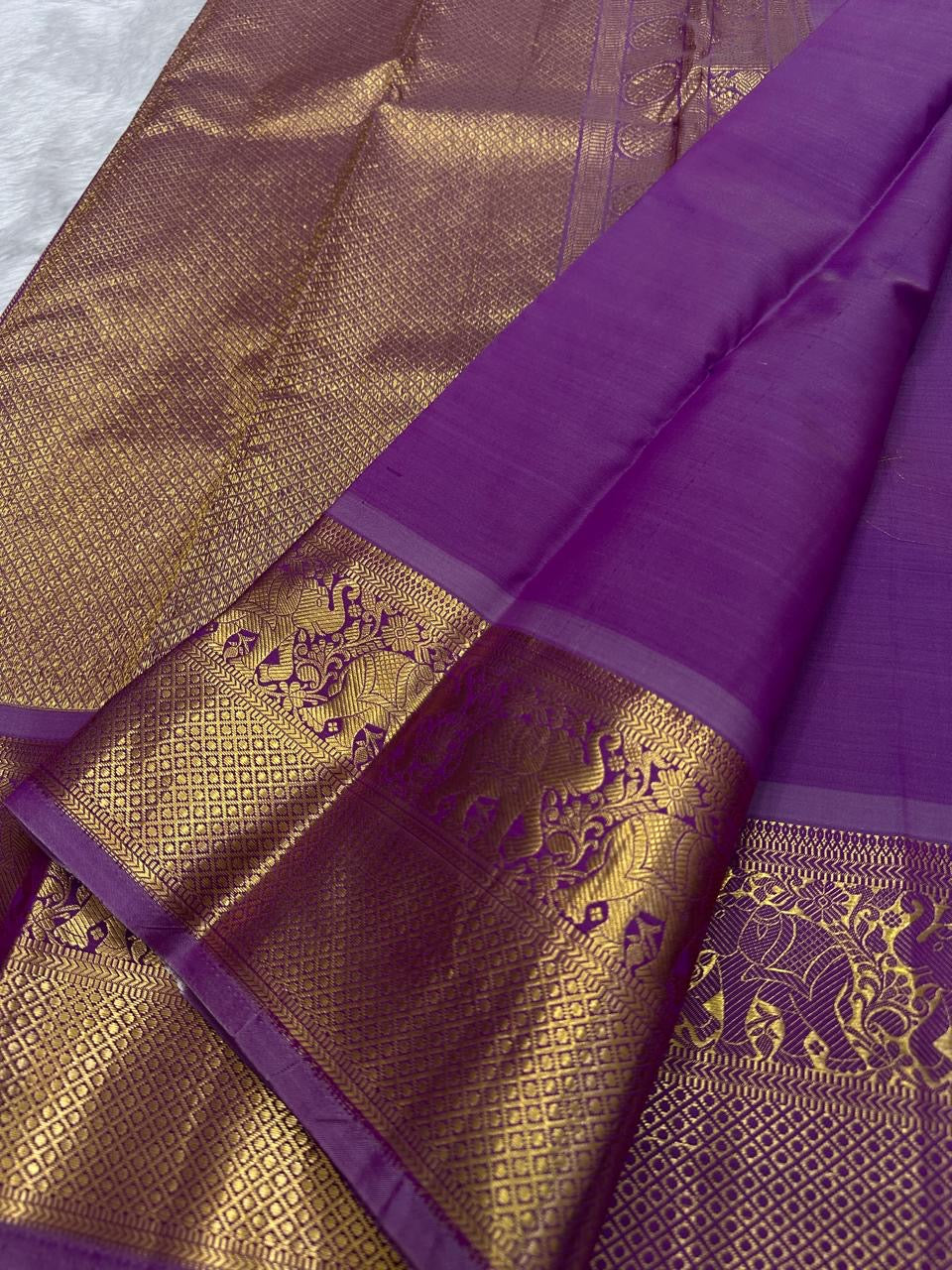 Close-up of elephant motif zari border on orchid purple Kanjipuram silk saree