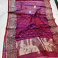 Folded berry red Chanderi Katan Silk saree with small silver blossoms and ornate silver-rose floral border