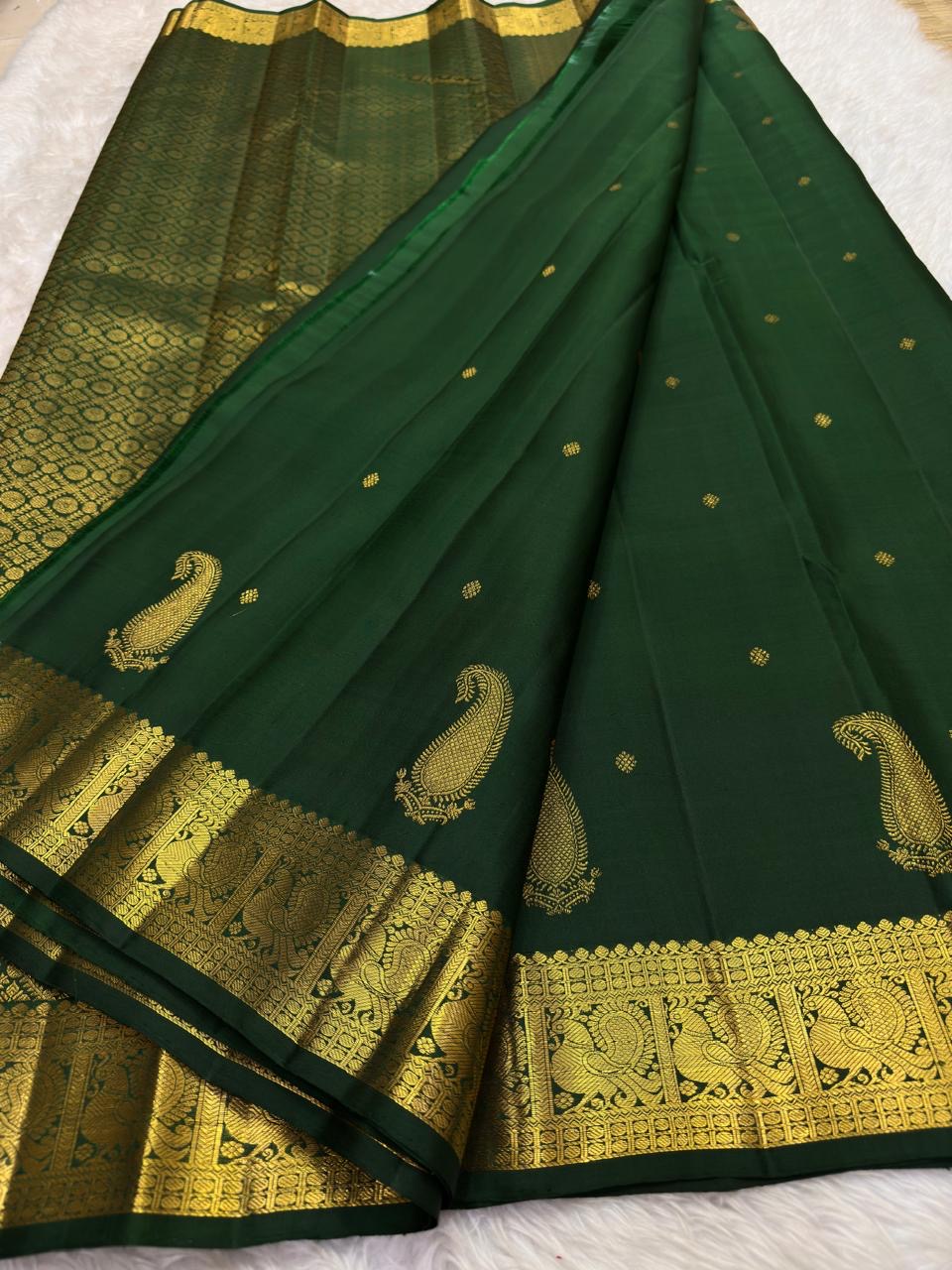 Traditional peacock motifs woven in gold zari along Kanchipuram silk border