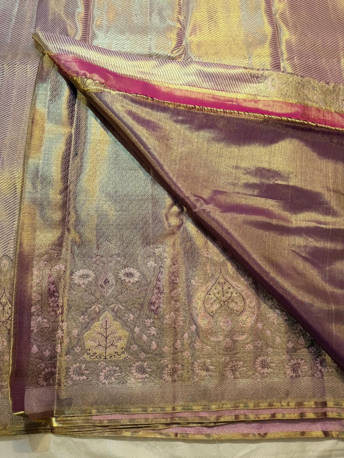 Lavender-gold brocade border with stylised tree motifs, leaf forms, floral rosettes and muted multicolour accents.