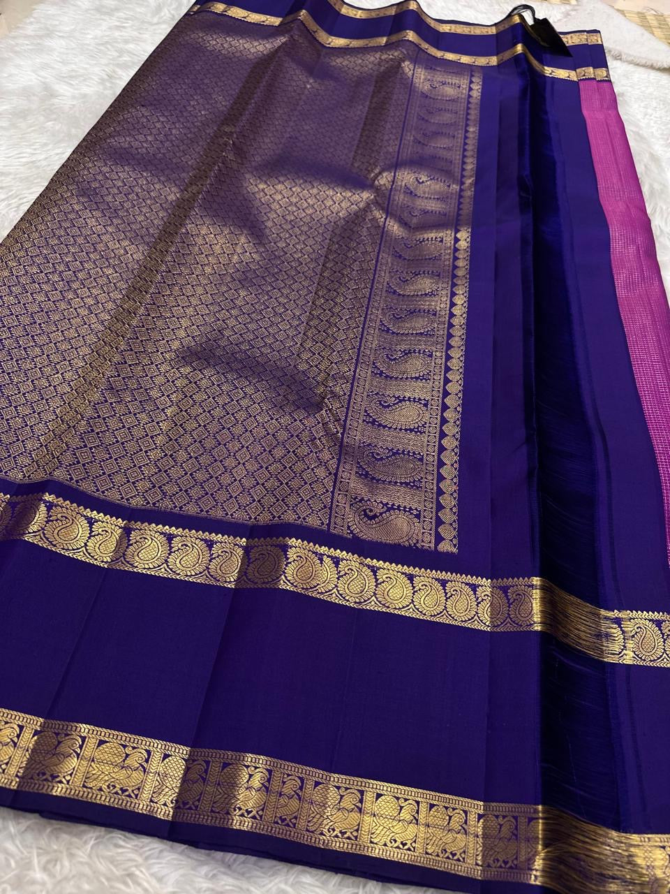 Close-up of petite gold zari buttas on raspberry pink Kanjivaram saree body
