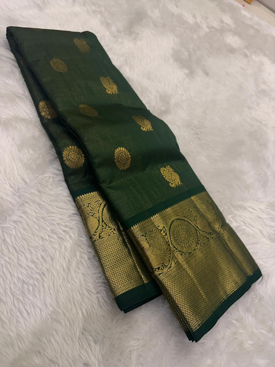 Handwoven Pure Silk Kanchipuram saree in deep maragatham green with a soft petal pink pallu with petite Gandaberunda zari buttas.