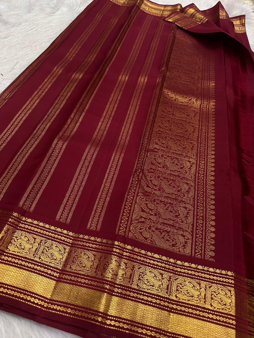 Burgundy Kanjivaram silk saree with floral vine Jaal and stylized Mayil-inspired gold zari motifs