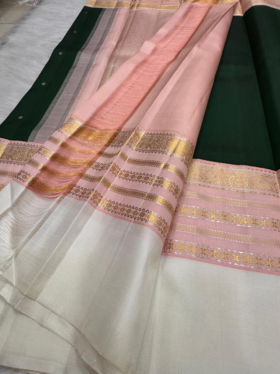 Pure Silk Kanjeevaram in Forest Green with layered Pink Ivory Varisaipet and traditional gold zari