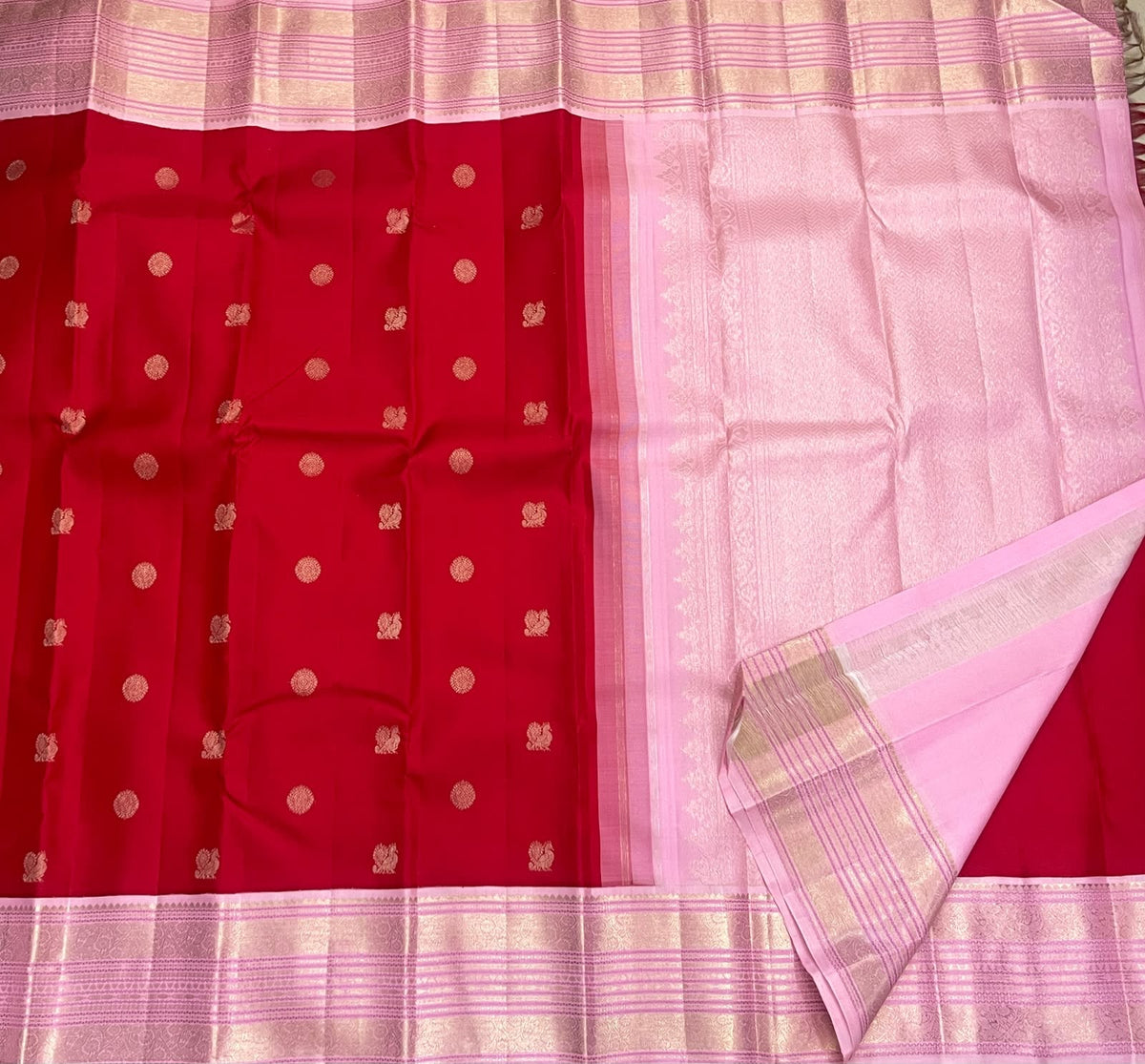 Close view of the rose-pink Kanchipuram border with broad floral zari registers and fine geometric bands.