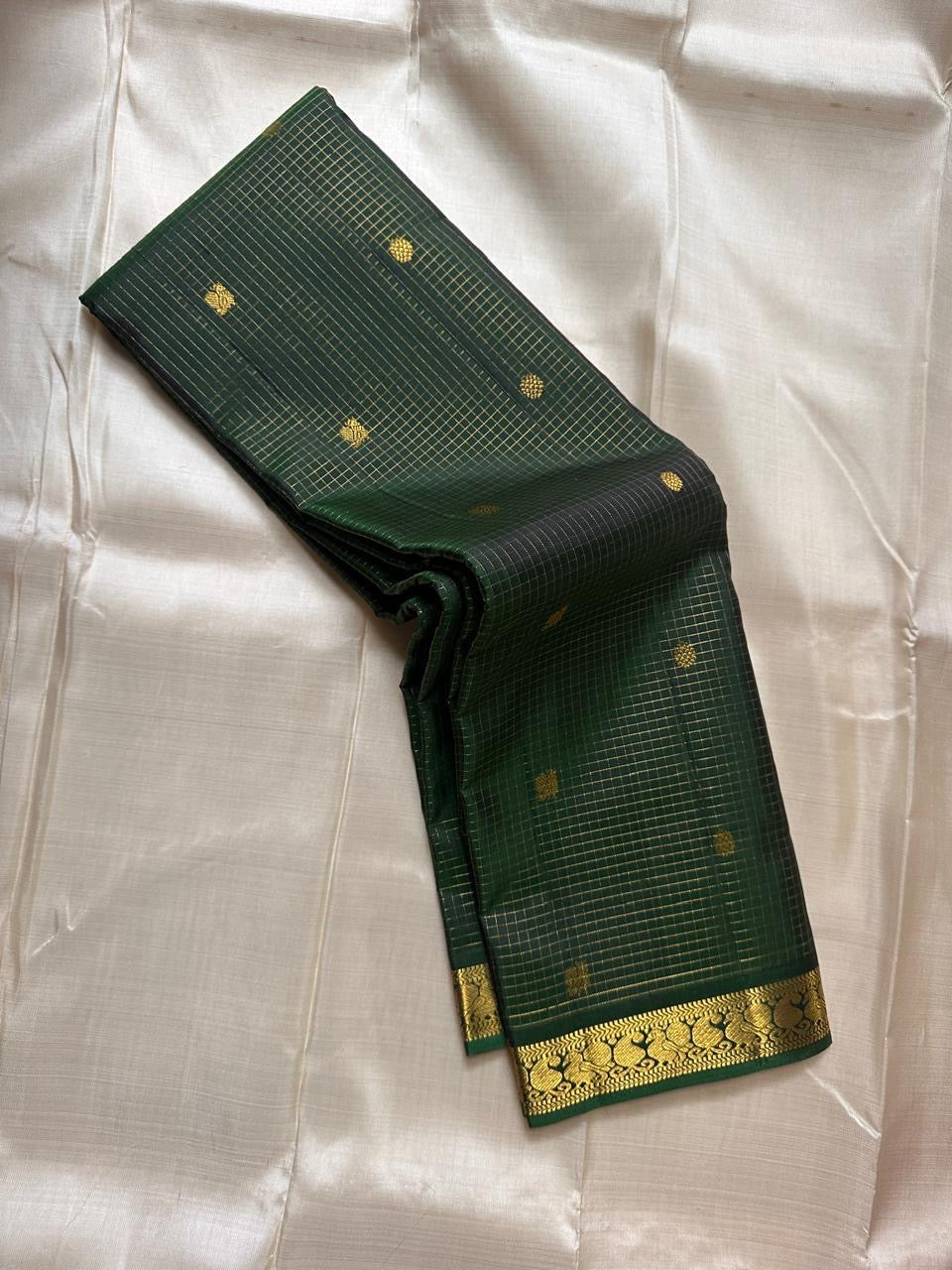 Dark bottle green handwoven pure silk Kanjipuram saree with Zari Kattam body Pavun coin butta and Mayil antique gold zari border overview