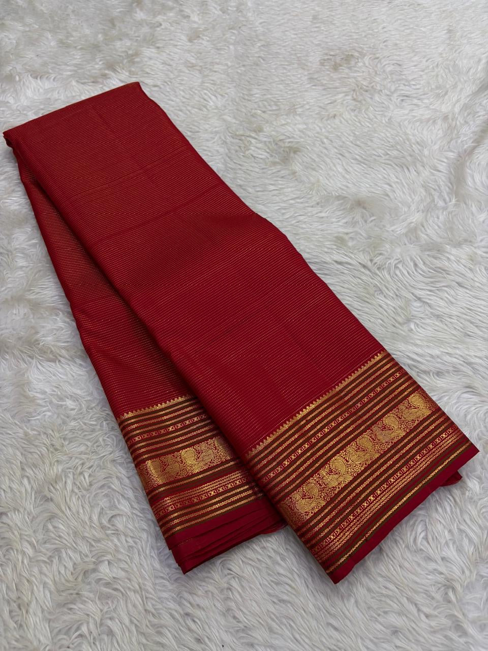 Pillar box red Kanchipuram silk saree folded on banana leaf with gold zari varisaipet border Idam Living