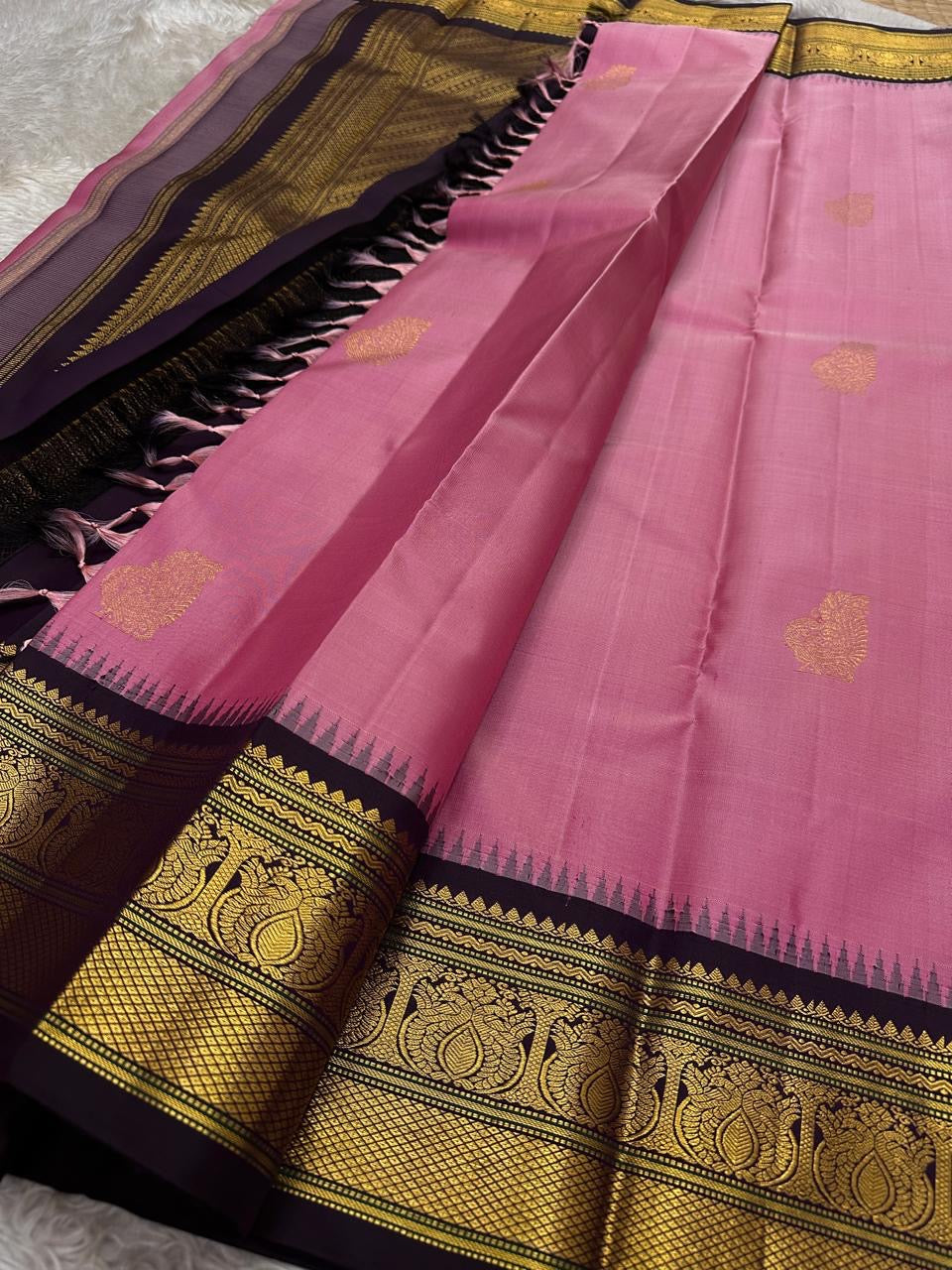 Draped pink Pure Kanchipuram Silk Saree with gold buttas and black zari border; black pallu with gold zari weave visible