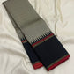 Folded grey Pure Kanchipuram silk saree showing black border with red selvedge and pillayar reku edge detailing.