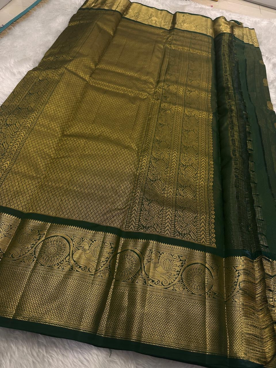 Close view of petite Gandaberunda zari buttas on the green silk body.