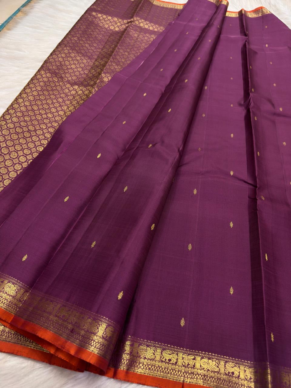 Close view of antique-gold leaf buttas on Muted Vadamalli Purple Kanjivaram silk.