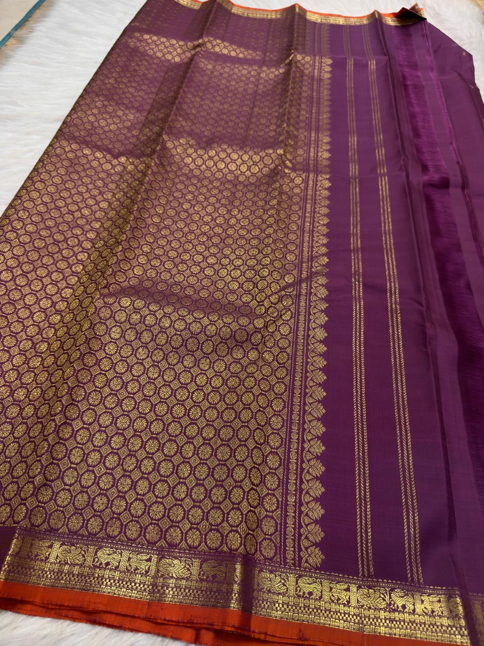 Burnt Orange selvedge finishing the border on Vadamalli Purple Kanchipuram saree.