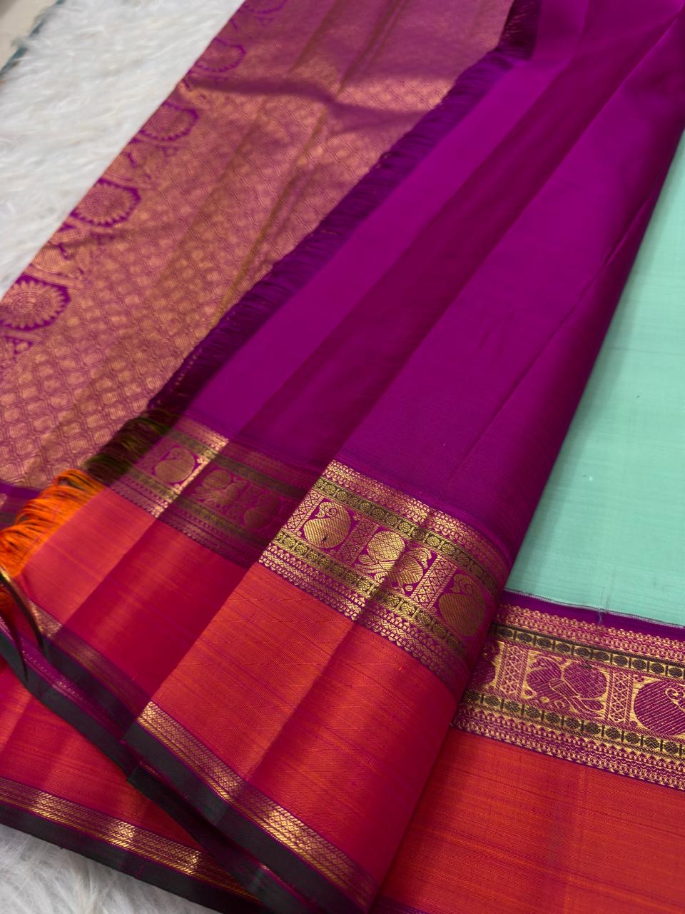 Detail of purple and coral Korvai border interwoven with silk thread, gold zari and Mayil motifs.