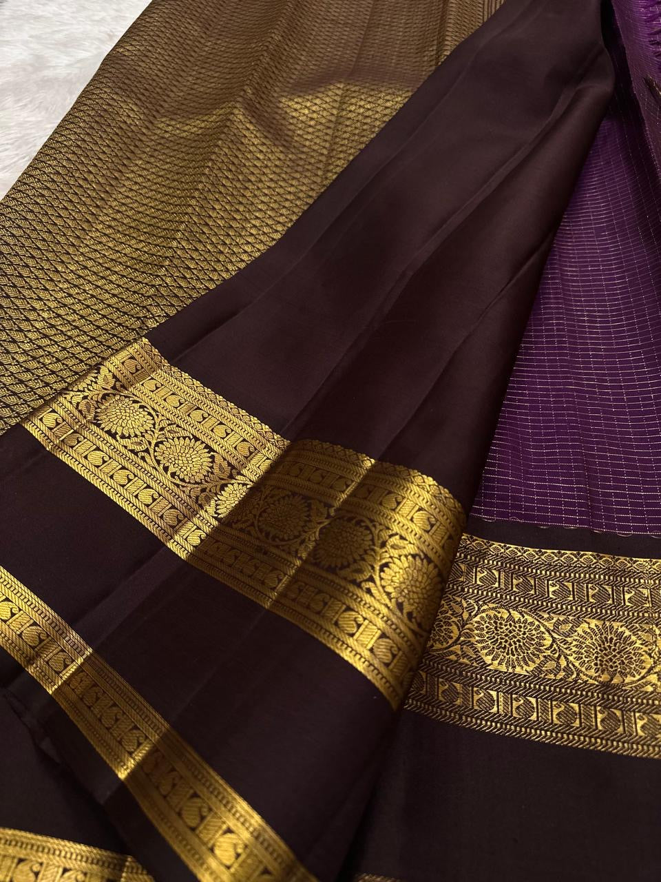 Purple Kanjivaram silk showing traditional gold zari motifs woven across the body.