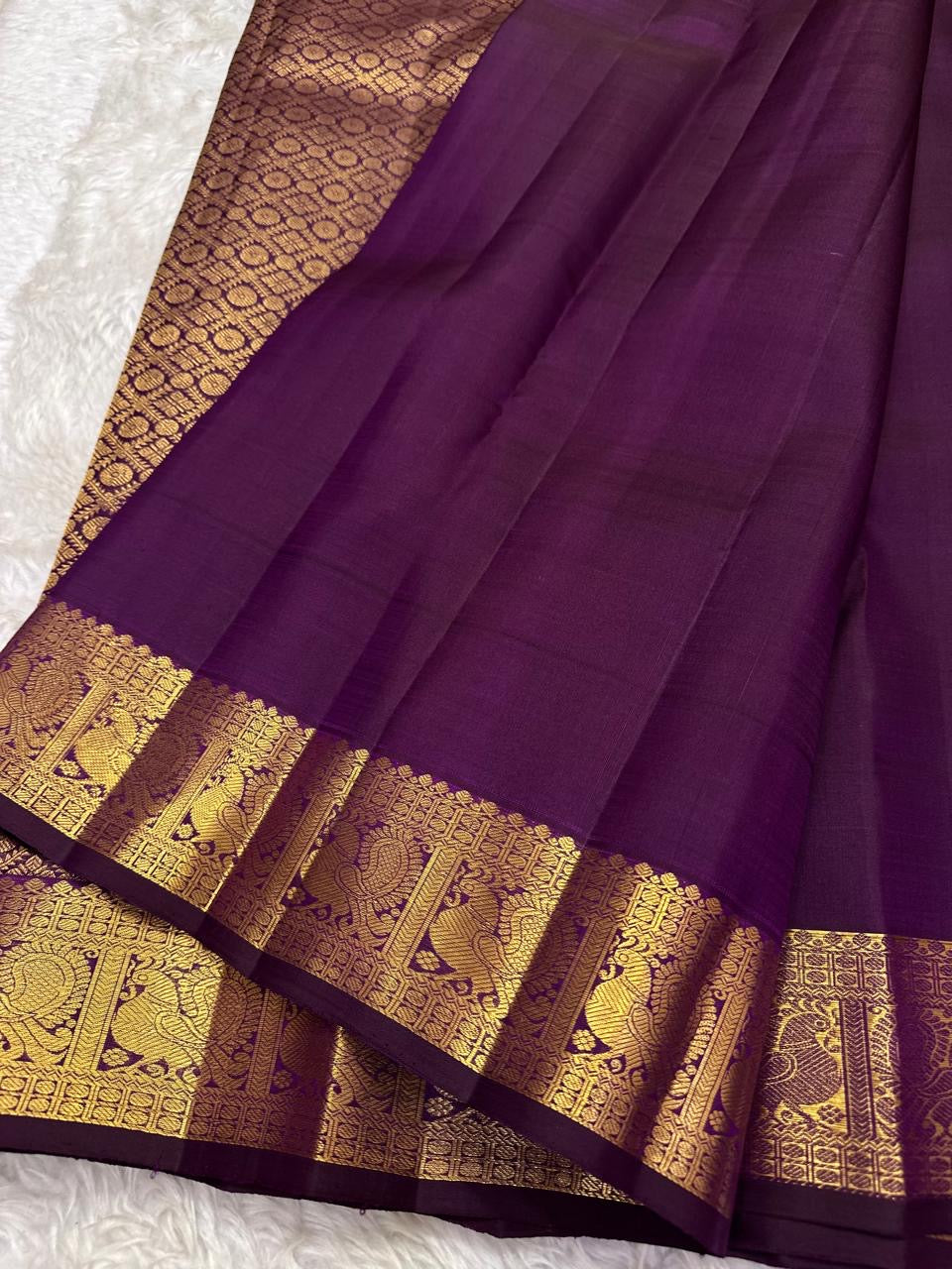 Ornate self-colour border of grape purple Kanjeevaram saree with Maanga and Mayil antique gold zari array