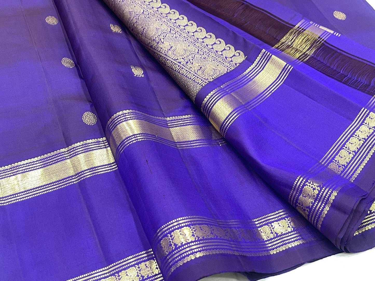 Layered purple Rettapet border with broad gold zari bands and floral register.