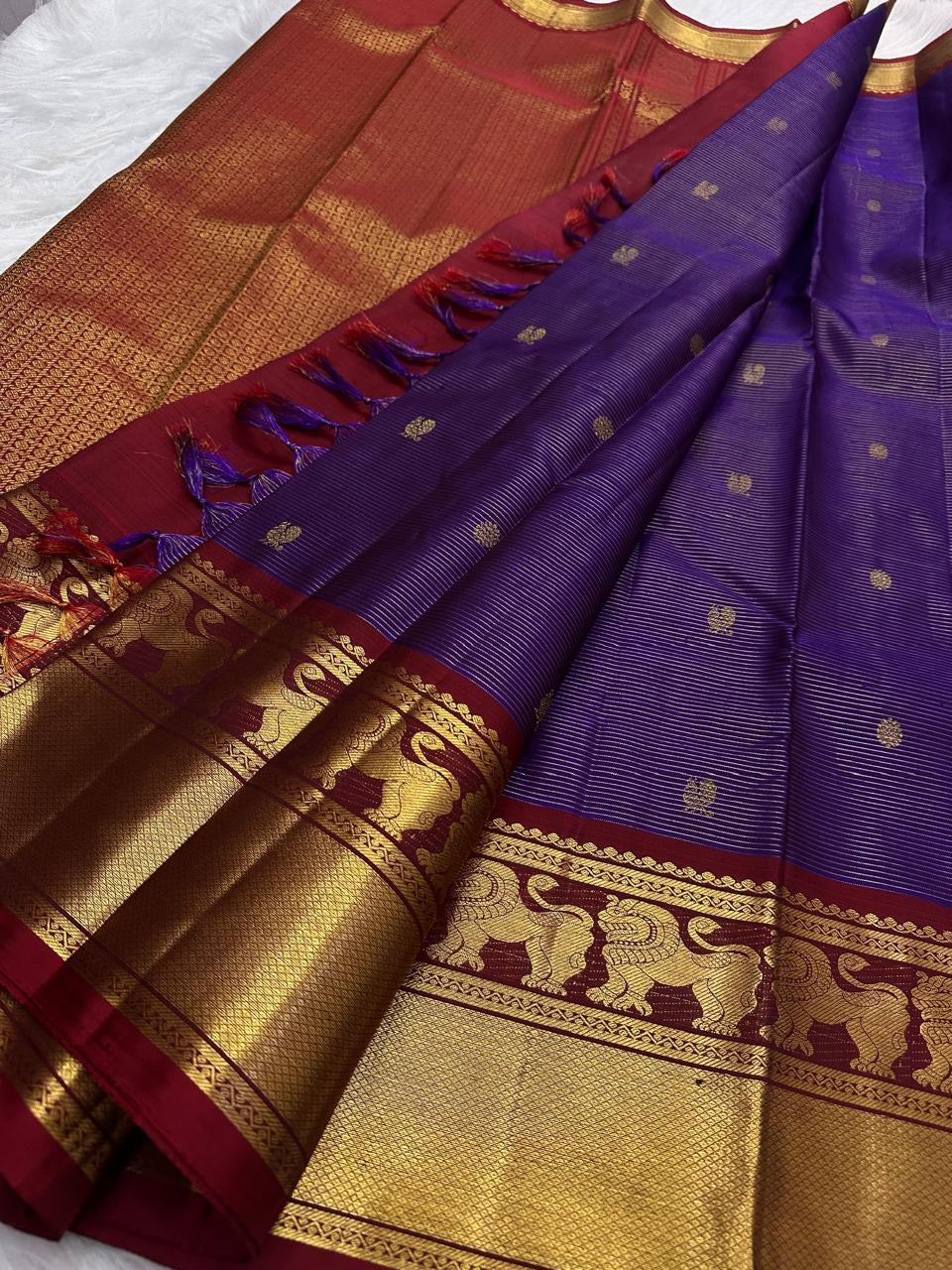 Deep Violet Pure Silk Vaira saree opened to show petite buttas, Arakku border and repeating gold zari Yazhis.