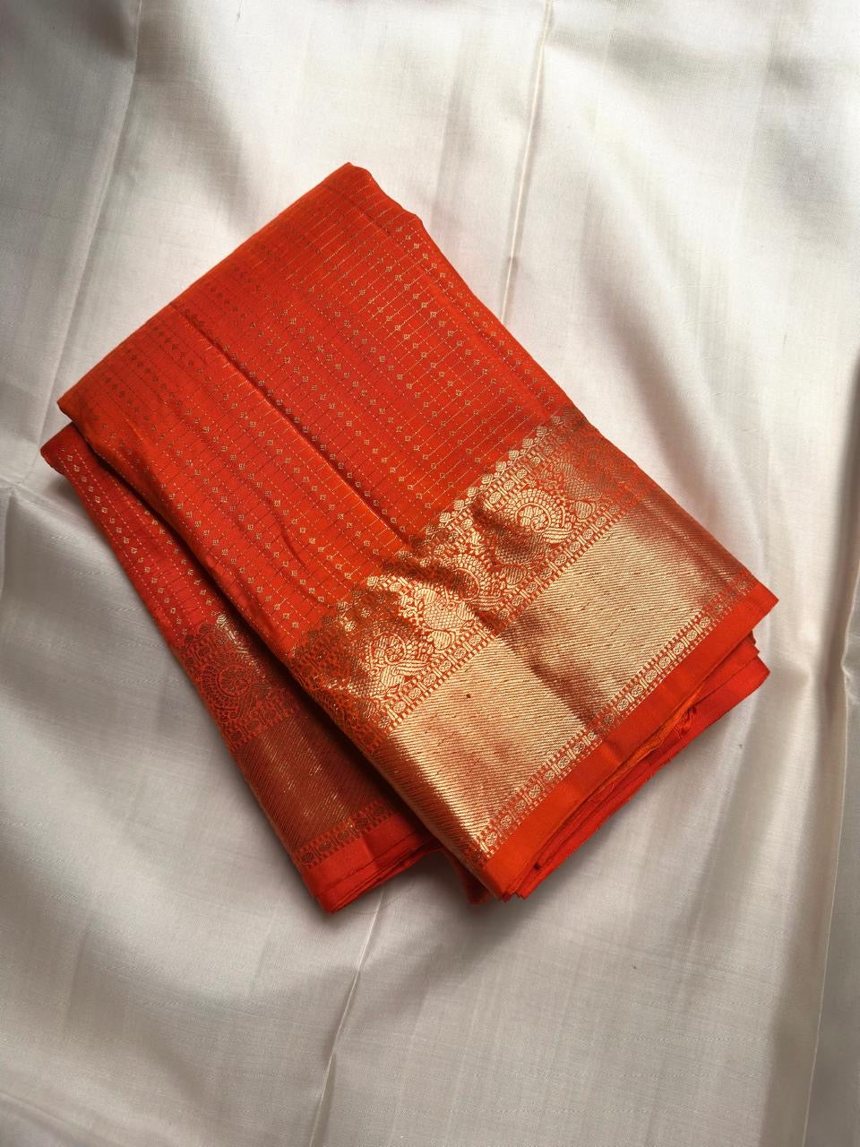Radiant Burnt Orange handwoven pure silk Kanjivaram Butta saree with antique-gold zari detailing.