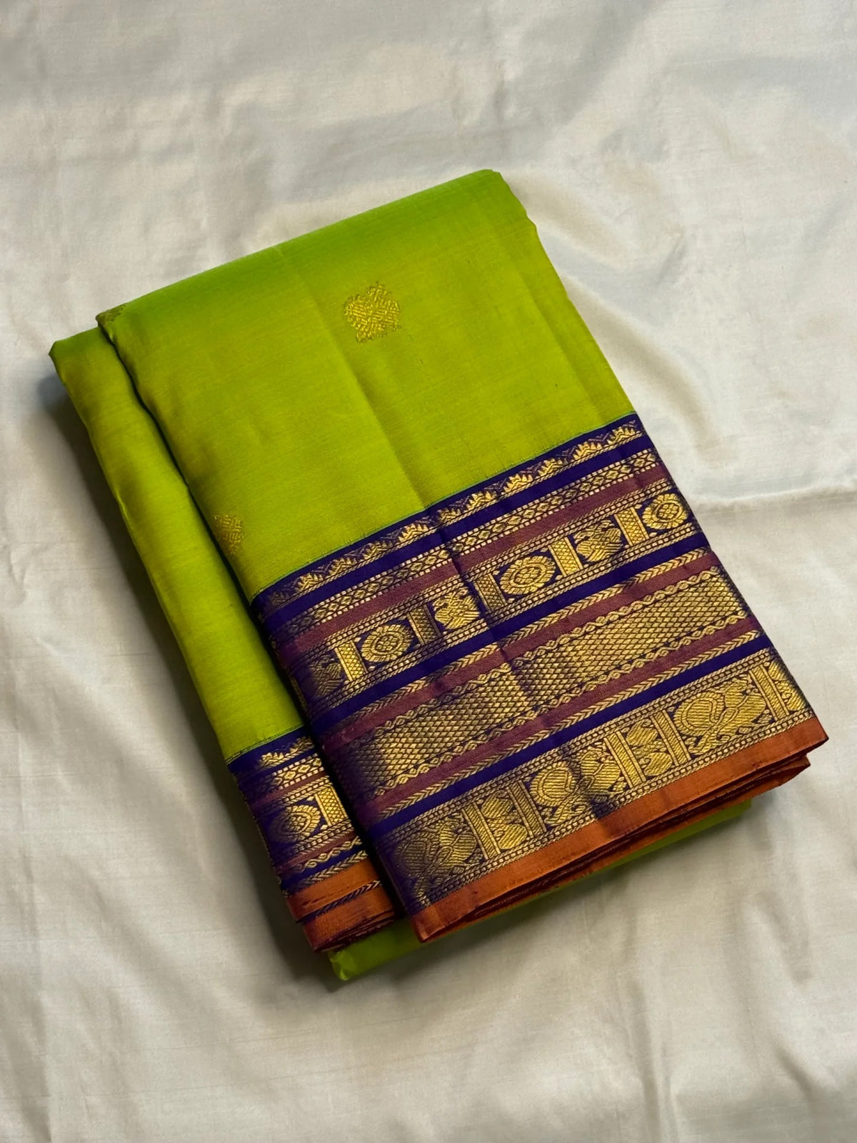 Bright lime-green silk body contrasted with a deep indigo-purple traditional woven border.