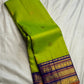 Handwoven green Kanchipuram saree showing scattered petite gold-toned zari buttas.