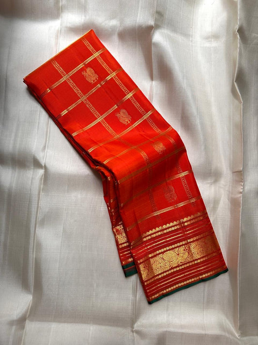 Orange Kanjivaram silk saree with traditional zari grid pattern draped view