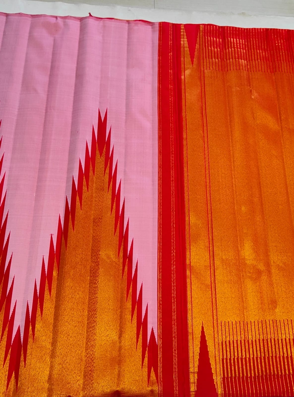 Close-up of ettukol red and gold flame motifs on radiant pink Kanchipuram pure silk saree — Idam Living