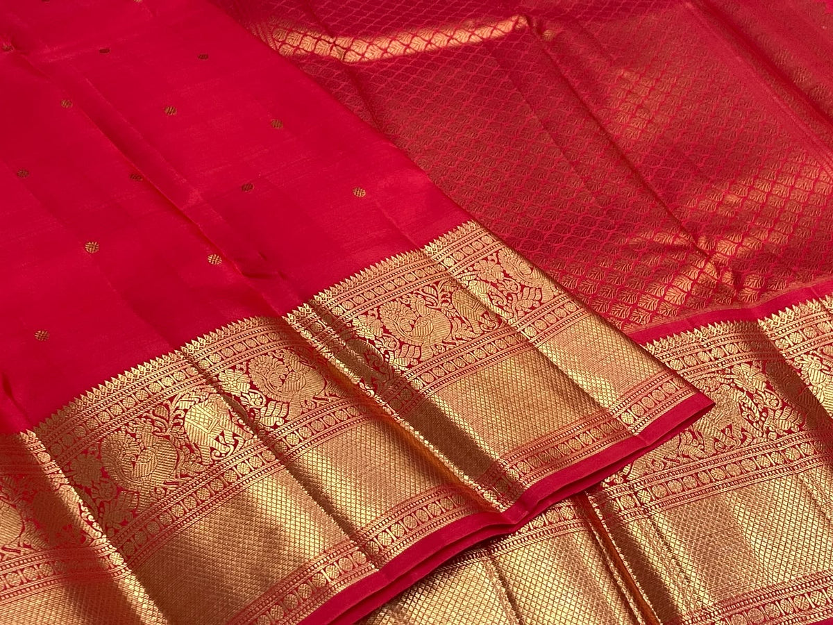 Radiant Vermilion Red pure silk Kanjivaram Butta saree with petite antique-gold zari motifs.