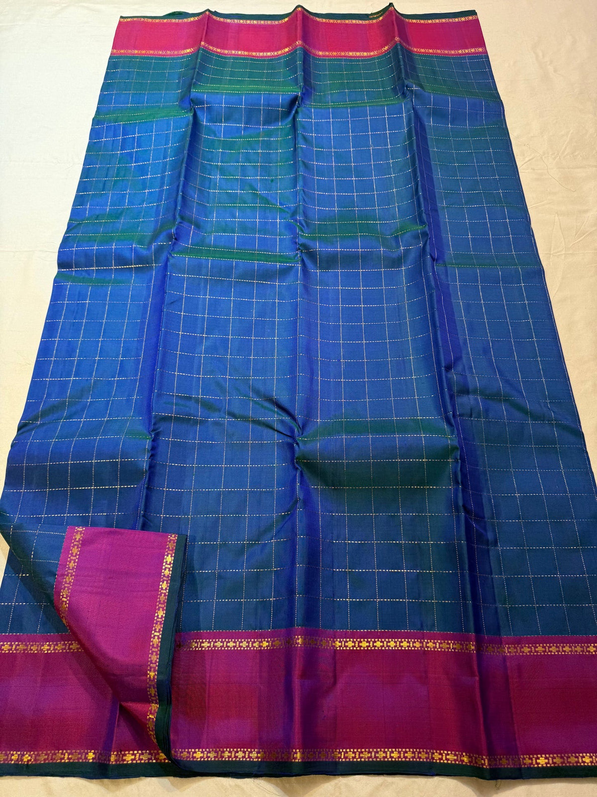 Pure silk Peacock Blue body woven with an evenly ordered antique-gold zari grid